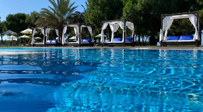 Poolbereich im ROBINSON Quinta da Ria an der Algarve mit Daybeds und Palmen