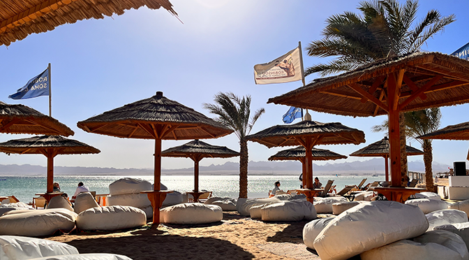 Strandbereich des ROBINSON Soma Bay mit Sonnenschirmen, Sitzsäcken und Blick auf das Rote Meer