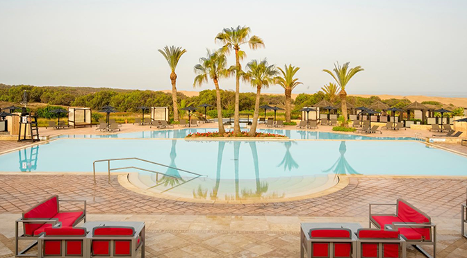 Poolanlage eines ROBINSON Clubs in Marokko mit Palmen und stilvollen Lounges