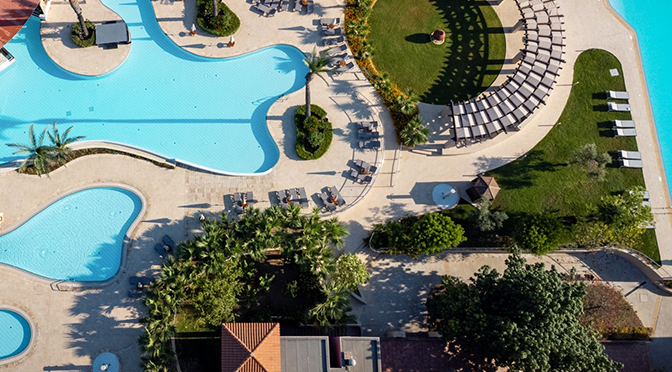 Poolanlage eines ROBINSON Clubs auf Zypern mit Palmen und Meerblick