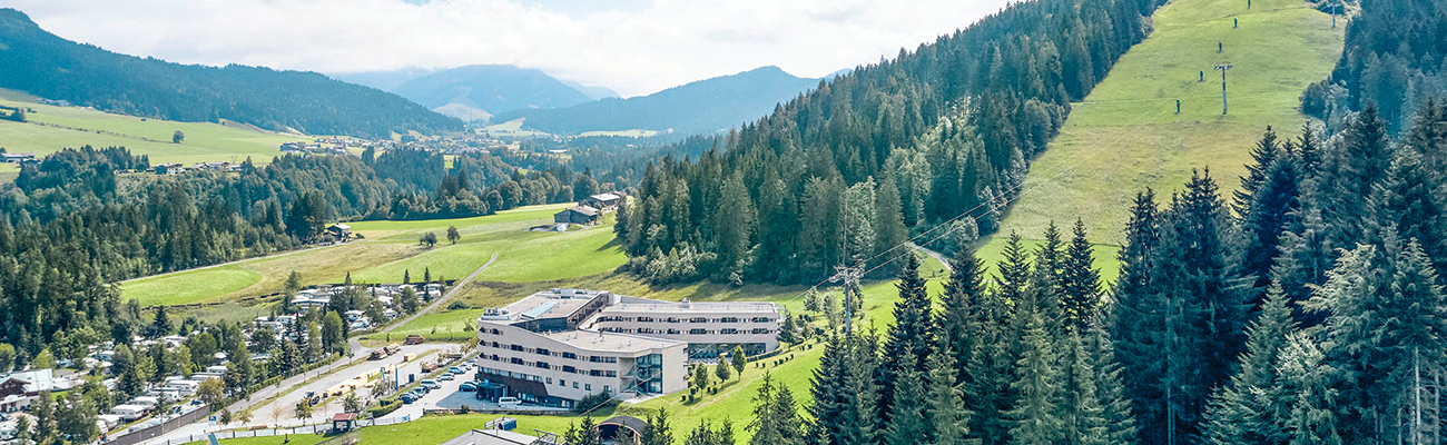 ROBINSON Fieberbrunn in Österreich mit Hotelanlage, grünen Alpenwiesen und Bergpanorama